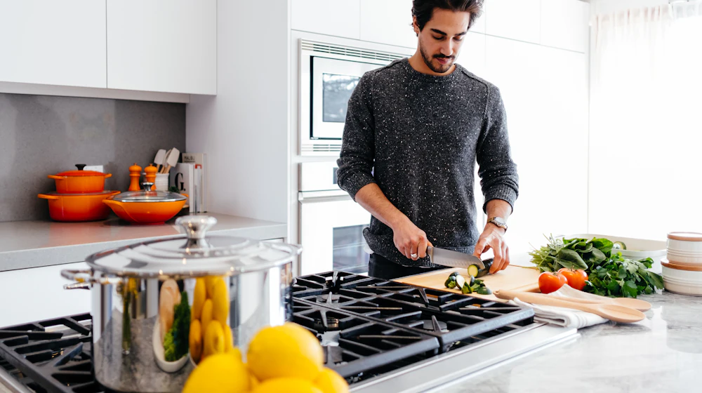 Hombre preparando verduras en la cocina